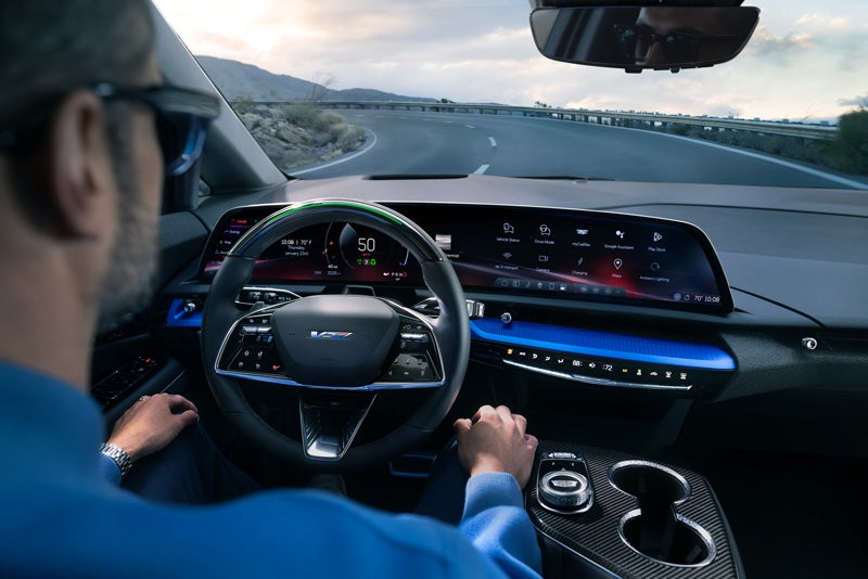 Front View of the 2026 OPTIQ-V Driving Through the Dusk Utilizing its Headlights | Star Cadillac in Quakertown PA